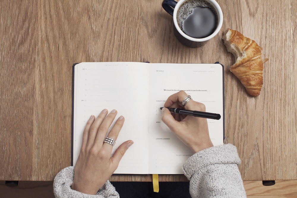 Man taking notes while reviewing medical educational materials
